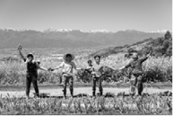 『むすび農園』の　畑の前で　手をつないで集まっている　「援農ボランティア」の　母親たちの写真
